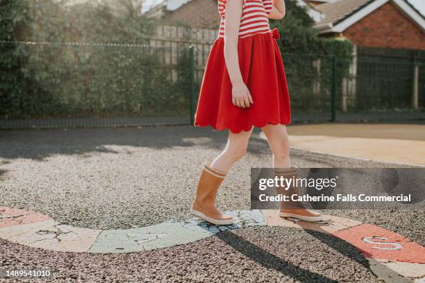 close-up of a child's feet walking across an alphabet snake in a play park - snakes and ladders stock pictures, royalty-free photos & images