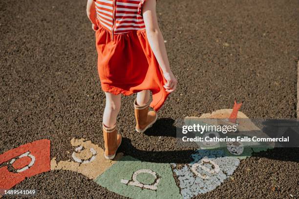 a child walks over an alphabet snake in a playpark - snakes and ladders stock pictures, royalty-free photos & images