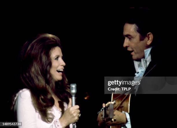 American singer, songwriter and dancer June Carter Cash and her husband, country singer Johnny Cash perform on stage during an episode of The Johnny...