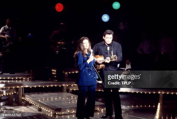 American singer, songwriter and dancer June Carter Cash and her husband, country singer Johnny Cash perform on stage during an episode of The Johnny...