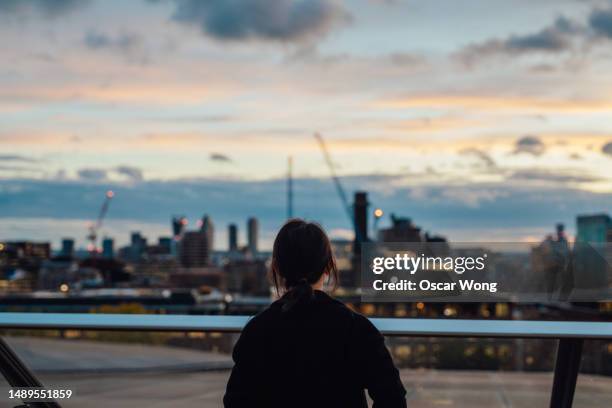 rear view of young asian business woman looking at city view in the financial district - rezar stock pictures, royalty-free photos & images