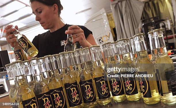 An employee grabs bottles of Drink Safran Kiwi , a fizzy drink with alleged aphrodisiac qualities carrying the initials of disgraced IMF chief...