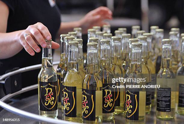 An employee grabs bottles of Drink Safran Kiwi , a fizzy drink with alleged aphrodisiac qualities carrying the initials of disgraced IMF chief...