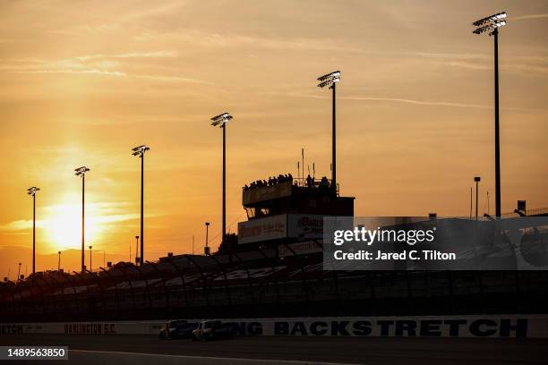 General view of racing as the sun sets during the NASCAR Craftsman Truck Series Buckle Up South Carolina 200 at Darlington Raceway on May 12, 2023 in...
