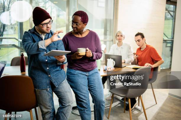 junger mann mit down-syndrom kooperiert mit seiner kollegin - chancengleichheit stock-fotos und bilder