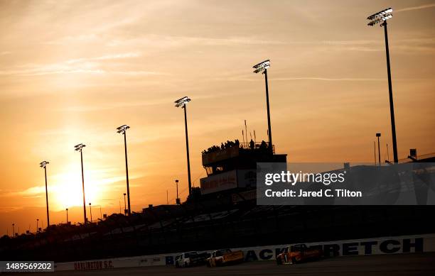 General view of racing as the sun sets during the NASCAR Craftsman Truck Series Buckle Up South Carolina 200 at Darlington Raceway on May 12, 2023 in...