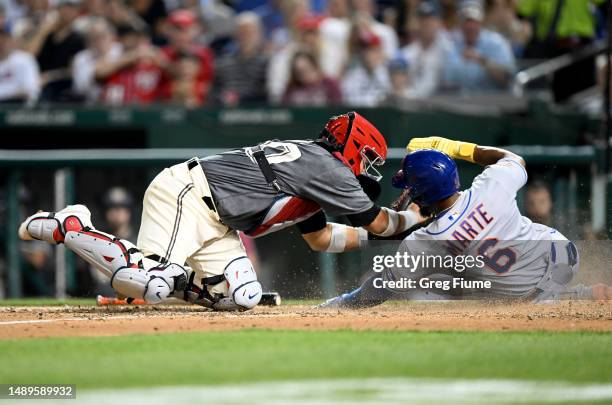 Starling Marte of the New York Mets is tagged out at home plate in the sixth inning by Keibert Ruiz of the Washington Nationals at Nationals Park on...