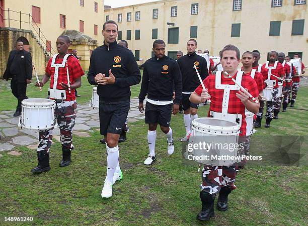 Antonio Valencia, Rio Ferdinand and Federico Macheda of Manchester United arrive with drummers in the new Manchester United away kit at the kit...