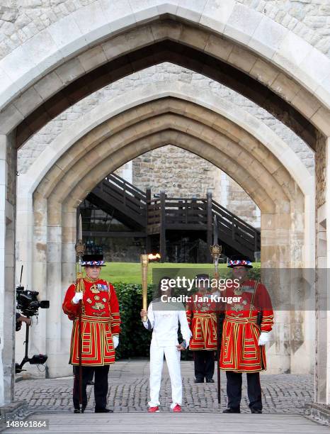 Dame Kelly Holmes poses with Beefeaters in the Tower of London during the London 2012 Olympic Torch Relay on July 20, 2012 in London, England. The...