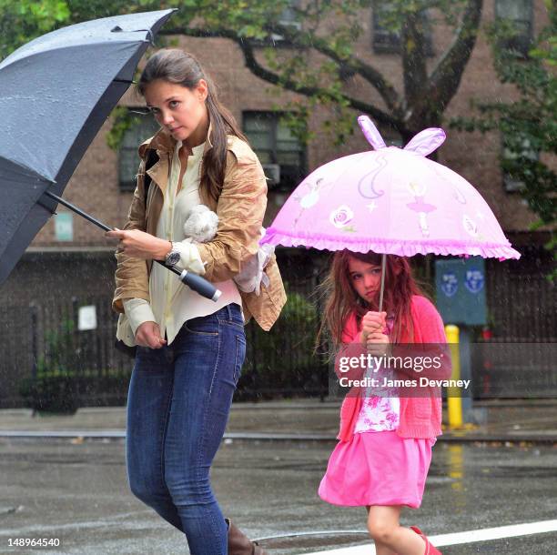 Katie Holmes and Suri Cruise seen walking in the rain in Chelsea on July 20, 2012 in New York City.