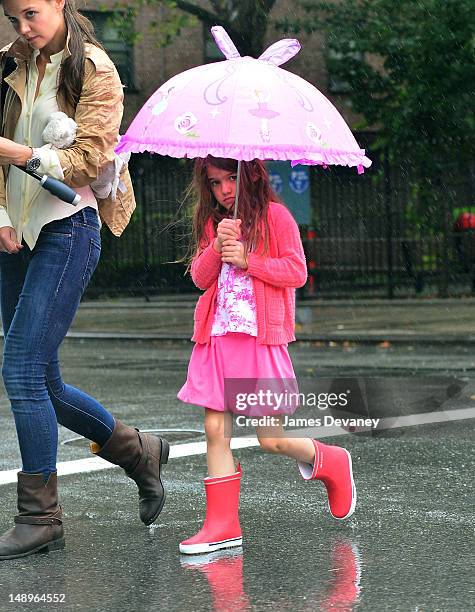 Katie Holmes and Suri Cruise seen walking in the rain in Chelsea on July 20, 2012 in New York City.