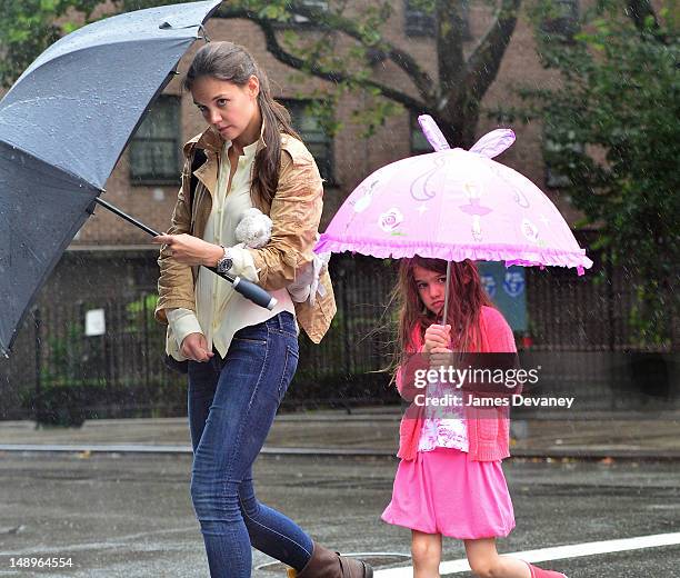 Katie Holmes and Suri Cruise seen walking in the rain in Chelsea on July 20, 2012 in New York City.