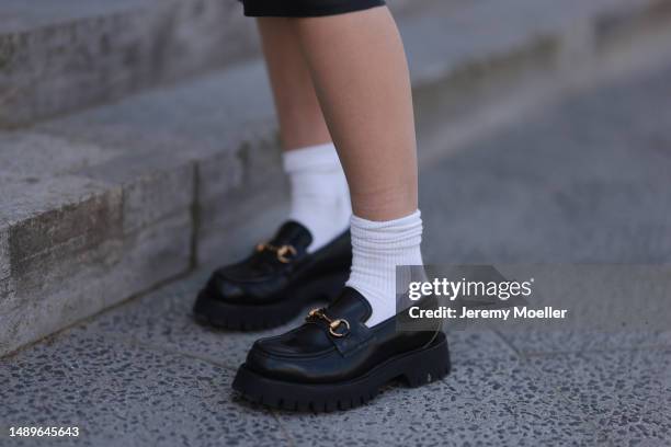 Alessa Winter seen wearing Gucci black leather loafer with golden details, white socks, The Frankie Shop Black leather midi skirt on May 12, 2023 in...