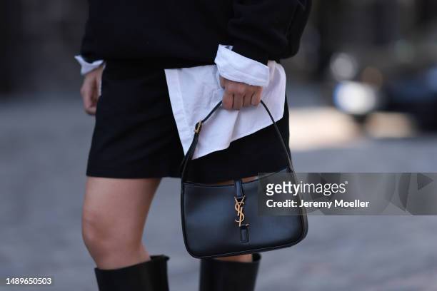 Alessa Winter seen wearing Nubikk black leather boots, YSL black leather golden logo bag, Fendi brown logo tie, Bottega Veneta black shades, The...