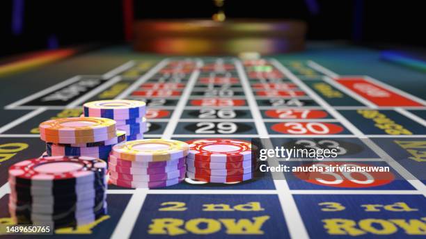 gambling chips placed on roulette wheel table - kasino stock-fotos und bilder