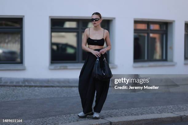 Alessa Winter seen wearing Miu Miu black logo bra top, vintage striped black oversized wide pants, Axel Arigato white sneaker, Bottega Veneta black...