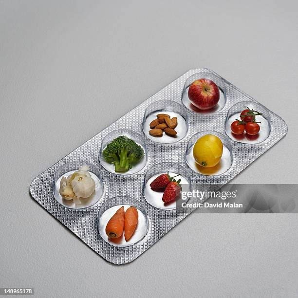 pill blister pack containing fruit and vegtables - nahrungsergänzungsmittel stock-fotos und bilder