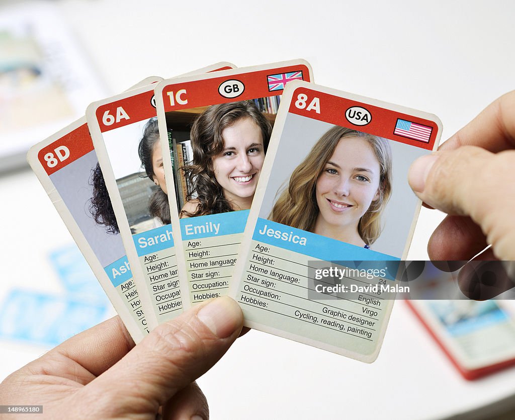 Man holding cards with various women's profiles