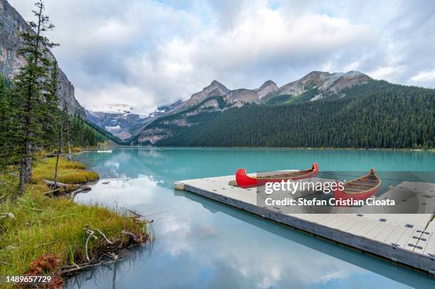two red boat on louise lake banff national park alberta canada - lake louise stock pictures, royalty-free photos & images