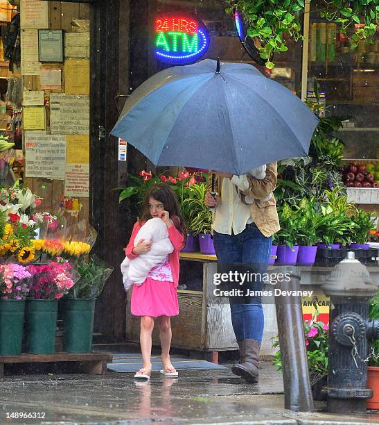 Katie Holmes and Suri Cruise seen walking in the rain in Chelsea on July 20, 2012 in New York City.