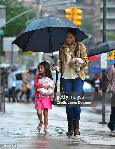 Katie Holmes and Suri Cruise seen walking in the rain in Chelsea on July 20, 2012 in New York City.