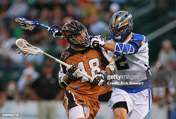Roy Lang of the Rochester Rattlers is checked by Jeremy Boltus of the Charlotte Hounds at Sahlen's Stadium on July 20, 2012 in Rochester, New York.