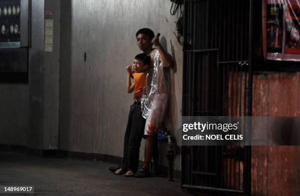 Hostage taker Remer Parparan points an icepick at 10 years old Jason Pineda during a hostage taking incident in Manila on July 21, 2012. The three...