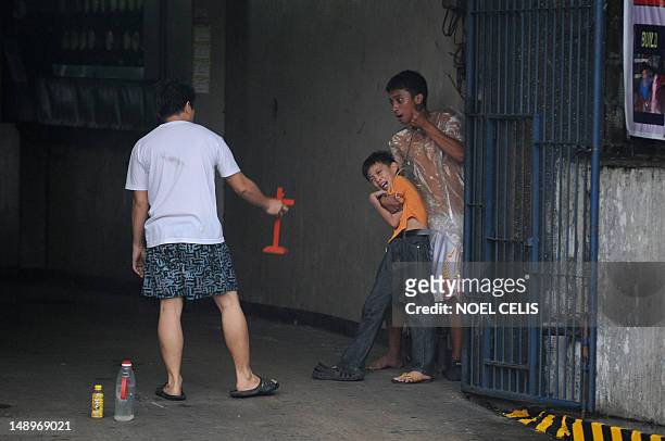 Man holds up a cross towards hostage taker Remer Parparan as he points an icepick against 10 years old Jason Pineda during a hostage taking incident...
