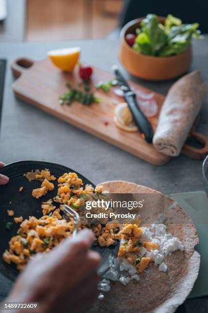 making wrapped sandwich for breakfast - wrapped burrito stock pictures, royalty-free photos & images