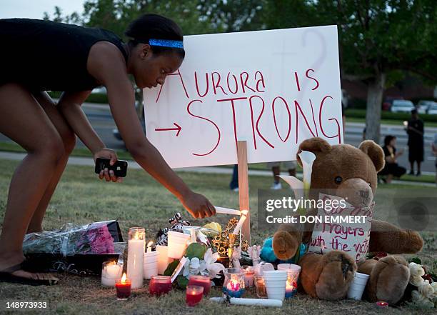 Mourners at a vigil light candles near theater where 12 people were killed July 20, 2012 in Aurora, Colorado. A graduate student who told police he...