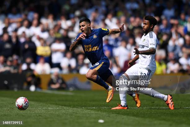 Bruno Guimaraes of Newcastle United runs with the ball from Weston McKennie of Leeds United before being yellow carded for simulation during the...