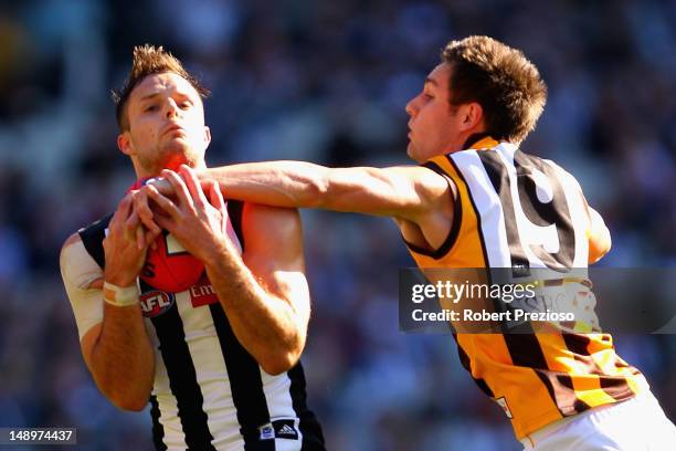 Nathan Brown of the Magpies takes a mark as Jack Gunston of the Hawks attempts to spoil during the round 17 AFL match between the Collingwood Magpies...