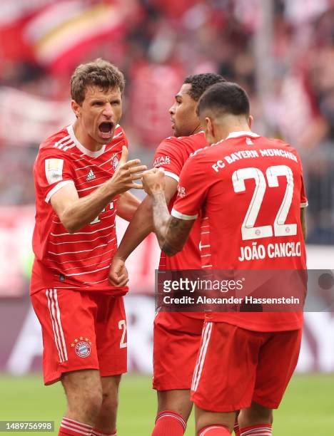 Thomas Mueller of FC Bayern Munich celebrates with teammate Joao Cancelo after scoring the team's first goal during the Bundesliga match between FC...
