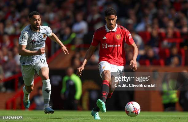 Raphael Varane of Manchester United passes the ball whilst under pressure from Matheus Cunha of Wolverhampton Wanderers during the Premier League...