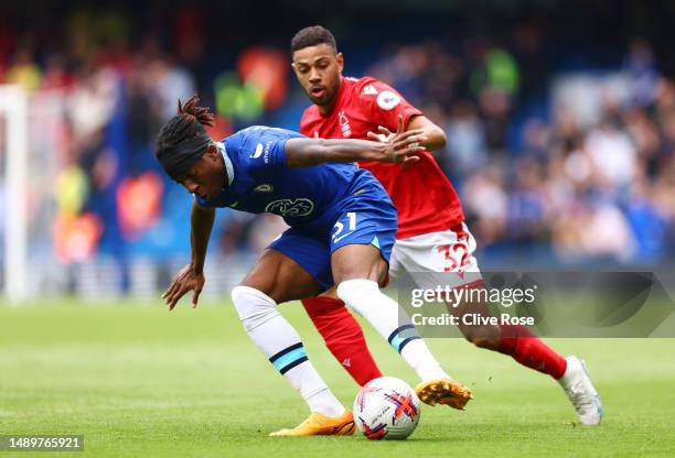 Noni Madueke of Chelsea is challenged by Renan Lodi of Nottingham Forest during the Premier League match between Chelsea FC and Nottingham Forest at...