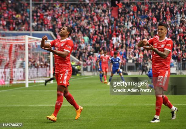 Serge Gnabry of FC Bayern Munich celebrates with teammate Joao Cancelo after scoring the team's third goal during the Bundesliga match between FC...