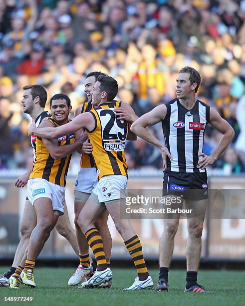 The Hawks celebrate after Jordan Lewis kicked a goal as Magpies captain Nick Maxwell looks on during the round 17 AFL match between the Collingwood...