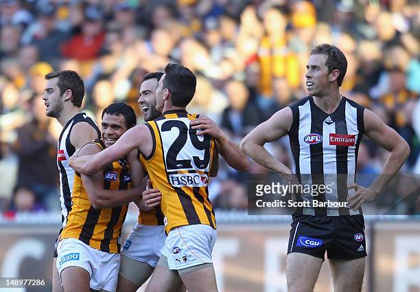 The Hawks celebrate after Jordan Lewis kicked a goal as Magpies captain Nick Maxwell looks on during the round 17 AFL match between the Collingwood...