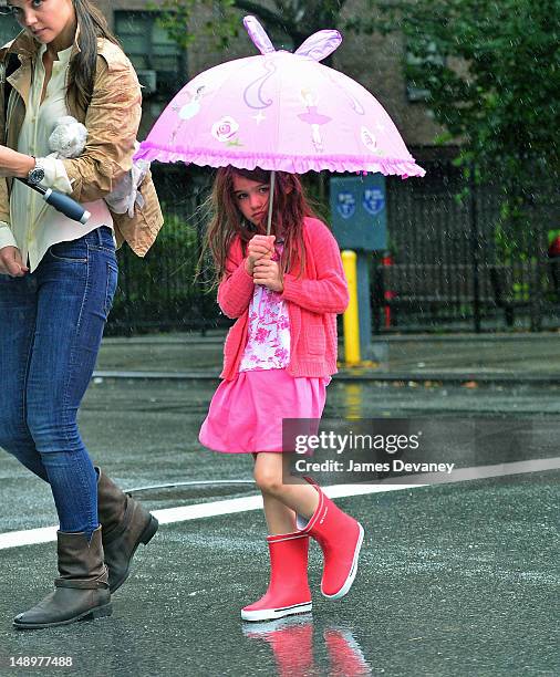 Katie Holmes and Suri Cruise seen walking in the rain in Chelsea on July 20, 2012 in New York City.