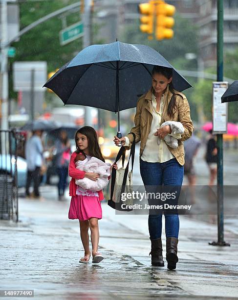 Katie Holmes and Suri Cruise seen walking in the rain in Chelsea on July 20, 2012 in New York City.