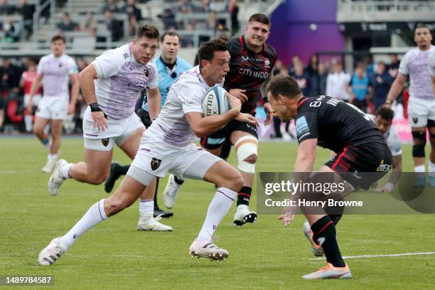 Alex Mitchell of Northampton Saints is challenged by Ivan Van Zyl of Saracens, before scoring the team's first try, during the Gallagher Premiership...