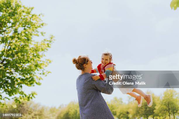 happy mom carrying her little daughter - carefree moment stock pictures, royalty-free photos & images
