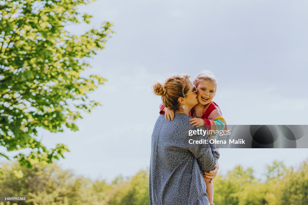 Happy mom carrying her little daughter