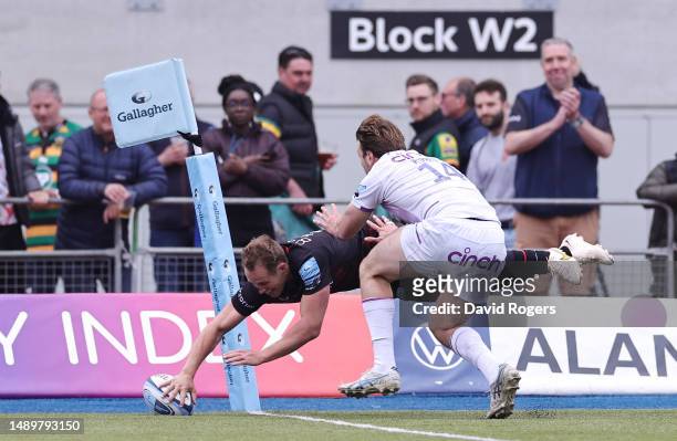 Max Malins of Saracens scores the team's fifth try whilst under pressure from James Ramm of Northampton Saints during the Gallagher Premiership...