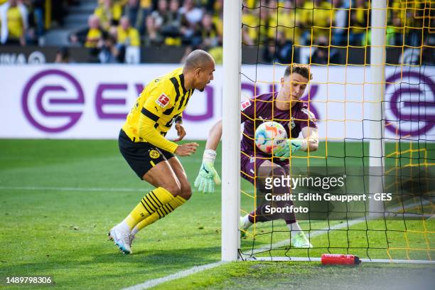 Donyell Malen of Dortmund scores his team's first goal against Jan Olschowsky of Moenchengladbach during the Bundesliga match between Borussia...