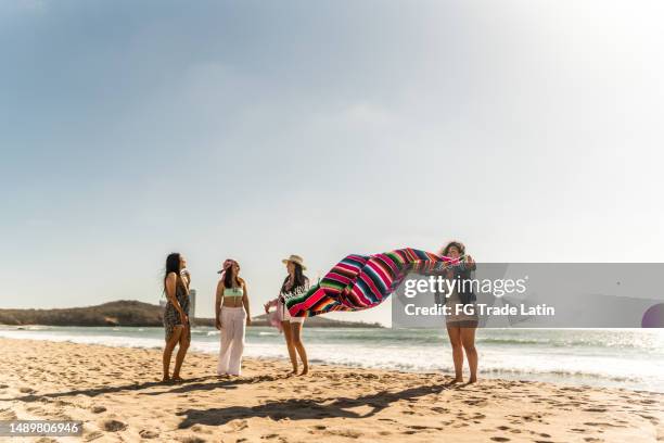 female friends preparing yoke to sit on the beach - yoke stock pictures, royalty-free photos & images