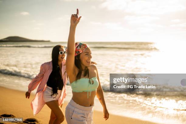 female friends having fun while walking on the beach - amigas felizes imagens e fotografias de stock