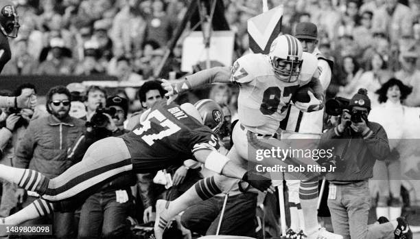 Miami TE Dan Johnson catches pass and heads towards the end zone as San Francisco LB Dan Bunz dives during game action at Super Bowl XIX of Miami...