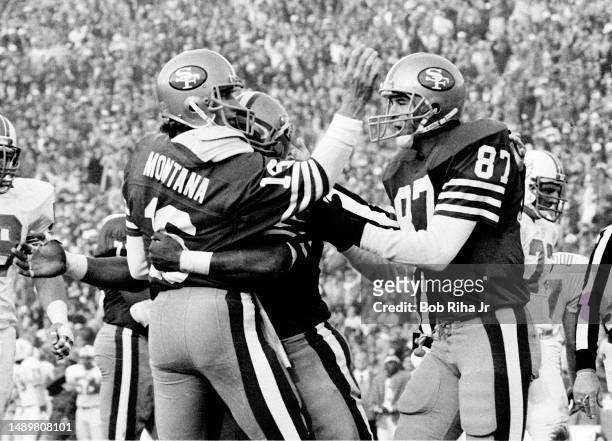 San Francisco QB Joe Montana runs for a touchdown and receives congratulations from teammates during game action at Super Bowl XIX of Miami Dolphins...