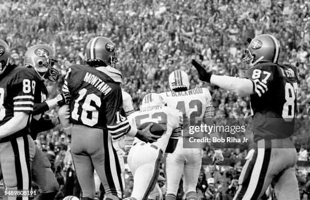 San Francisco QB Joe Montana runs for a touchdown and receives congratulations from teammates during game action at Super Bowl XIX of Miami Dolphins...